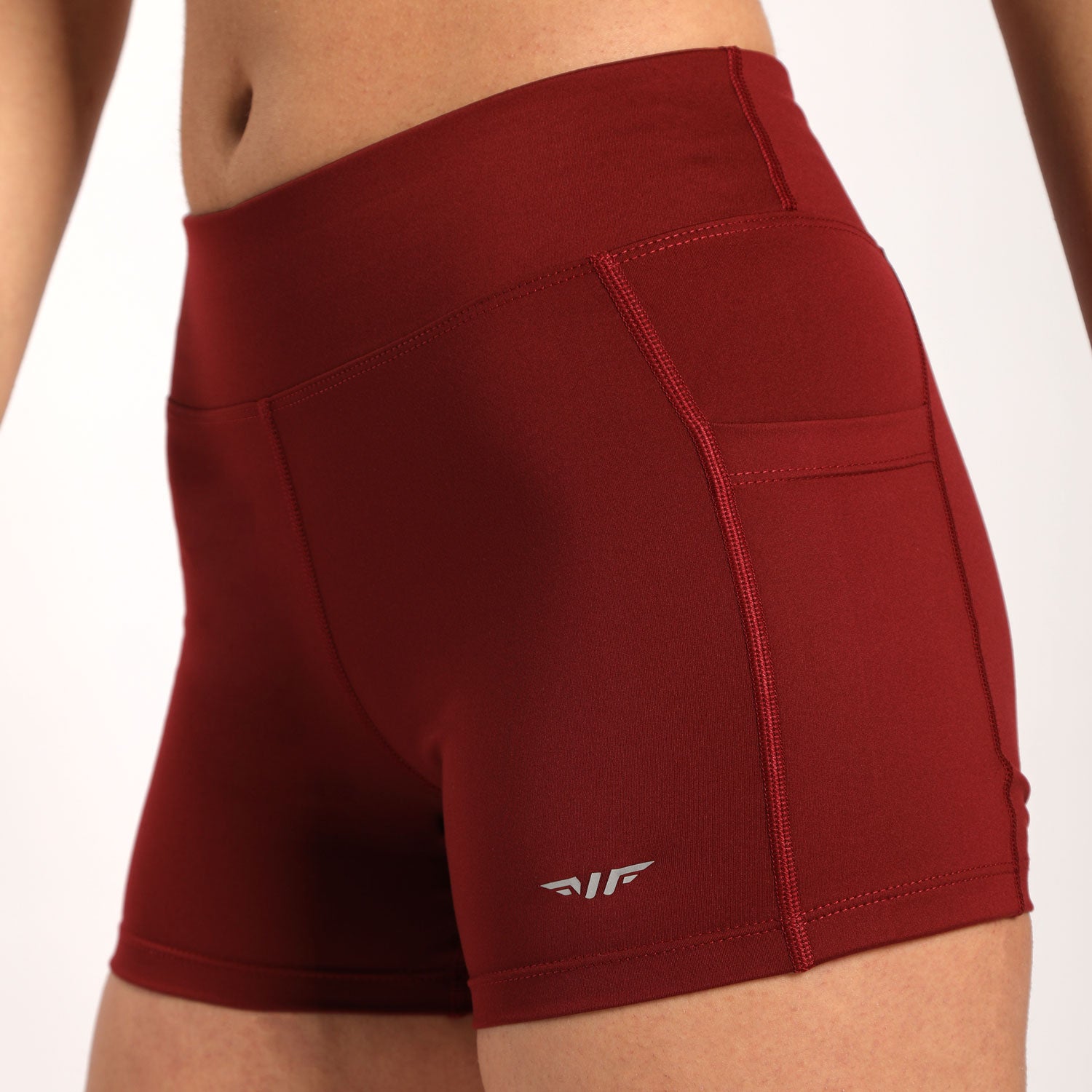 close up view for  woman wearing short red with logo ,plus the background is light grey  
