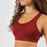 a woman wearing bras is red with  logo is same, plus the background  is light grey