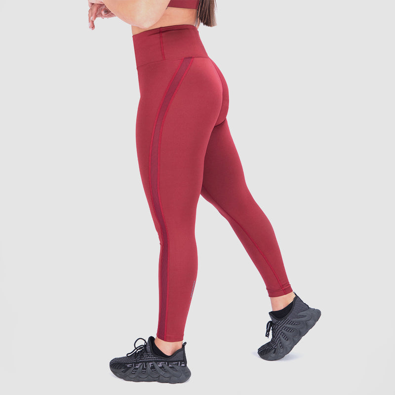 a fit woman stand at right and  wearing legging red with  shoes  black ,plus the background is light grey 