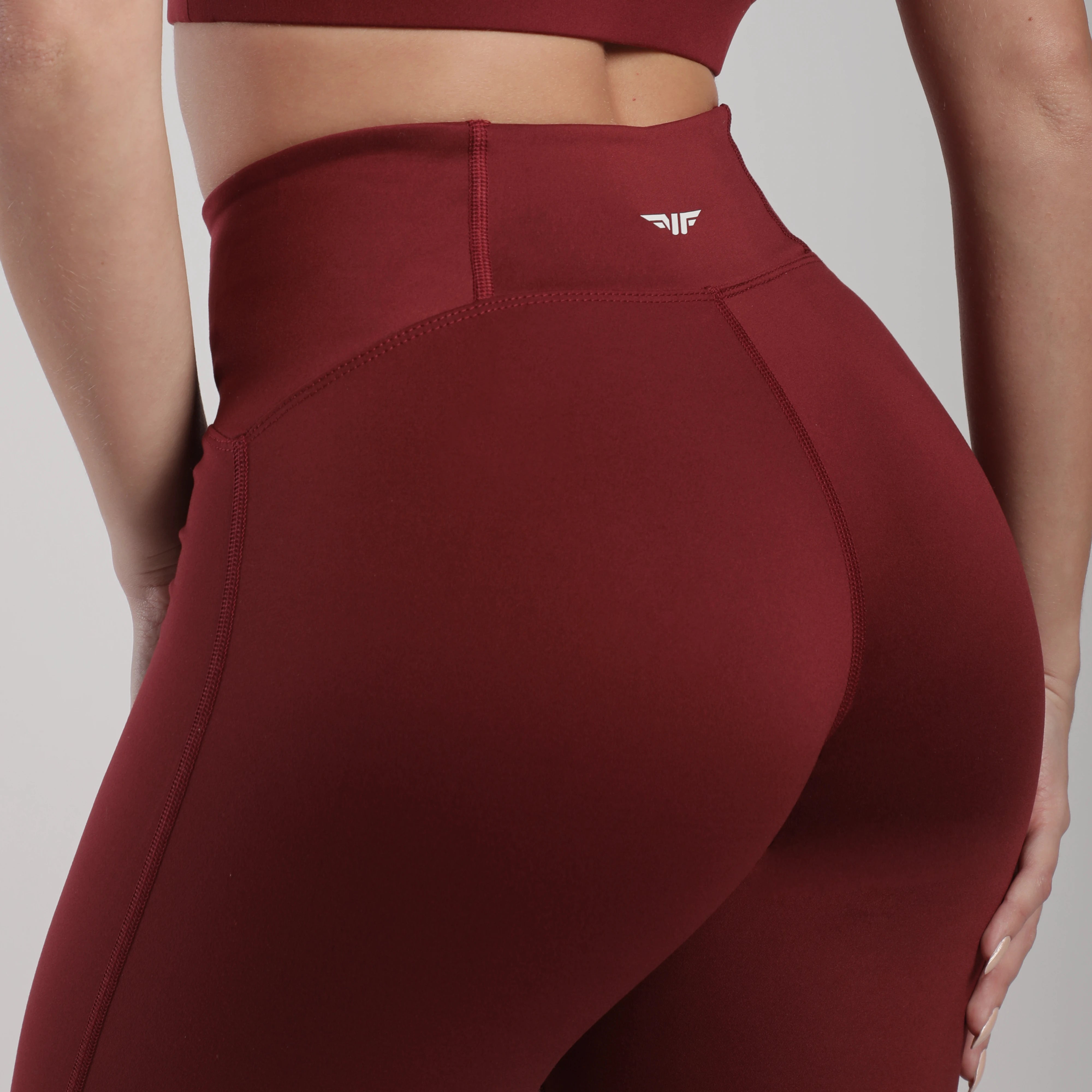 close up view for back view of woman wearing legging pomegranate with logo 