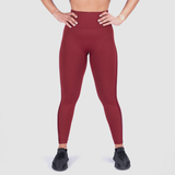a fit woman wearing legging red and shoes black ,the background is light grey 