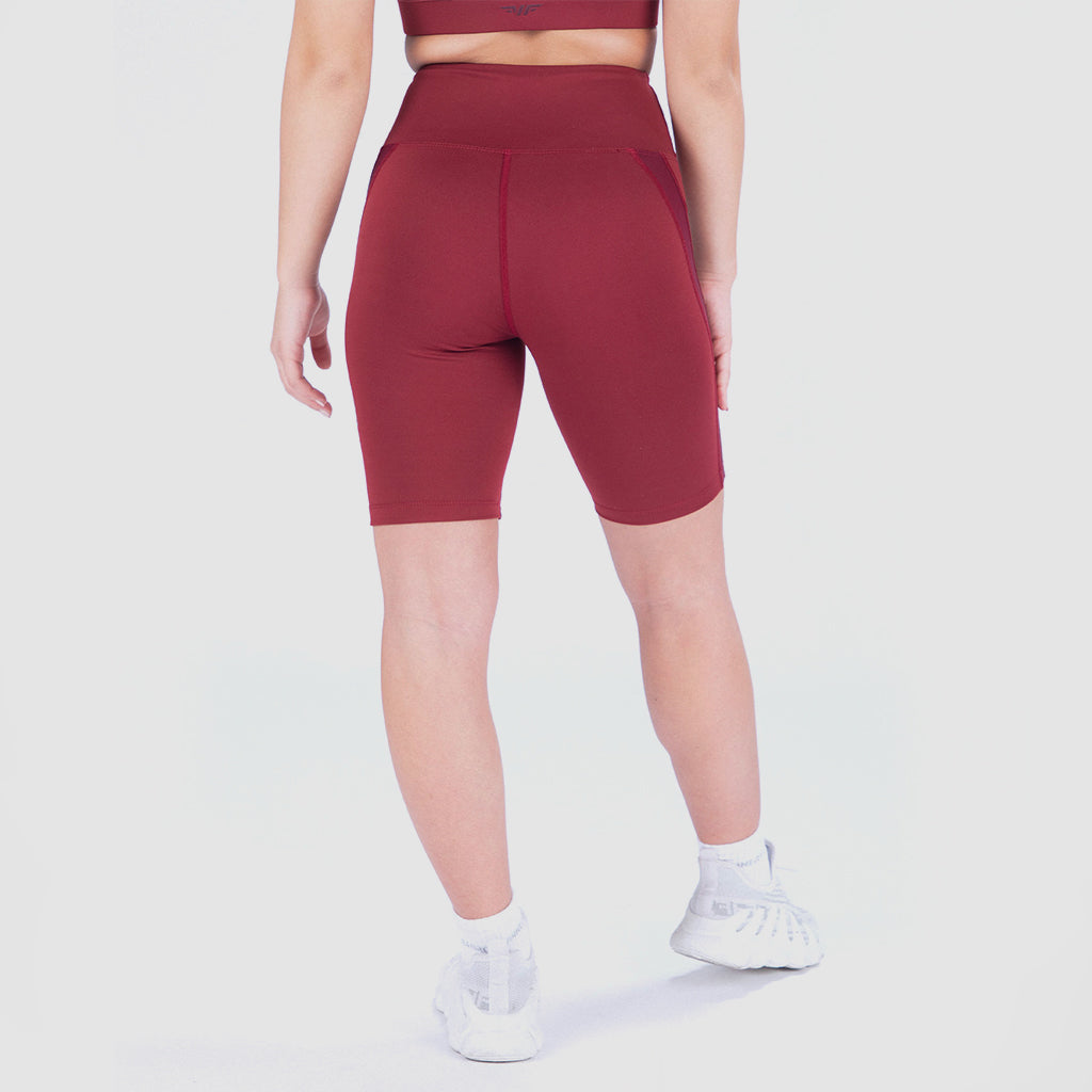 a back view for fit woman wearing seamless short red with socks shoes and shoes white ,plus the background is light grey 