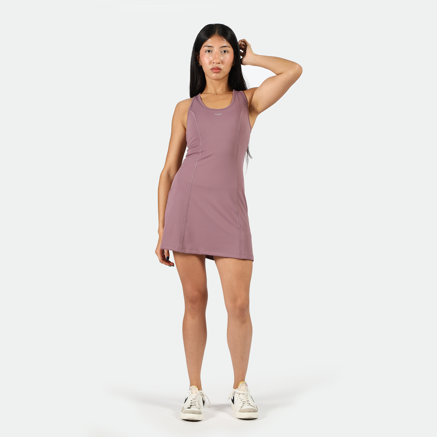 a fit woman wearing dress purple with sneakers 