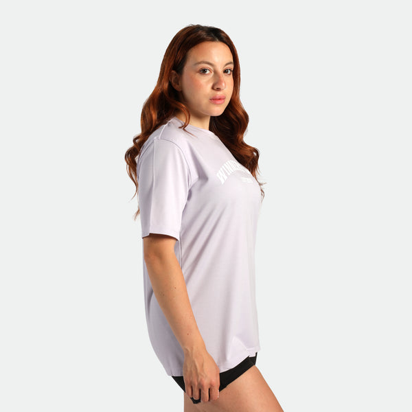 a fit woman stand at right and wearing t-shirt purple with short black 
