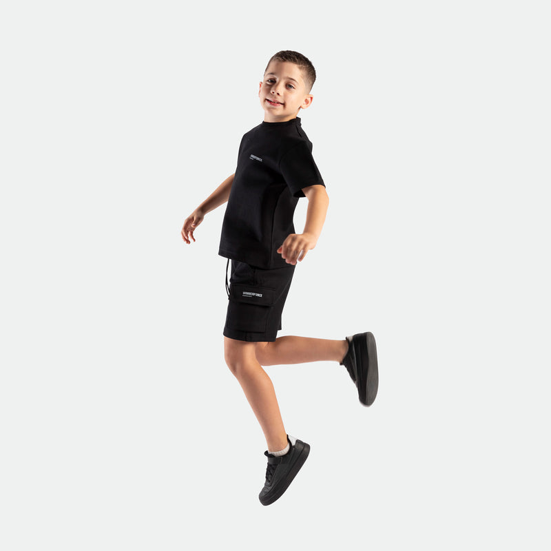 a fit boy stand at right and wearing matching set black ,t-shirt and short , plus shoes 