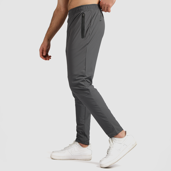 a fit man stand at right and wearing pants shade grey 