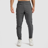 A man wearing quiet shade grey joggers and white sneakers.