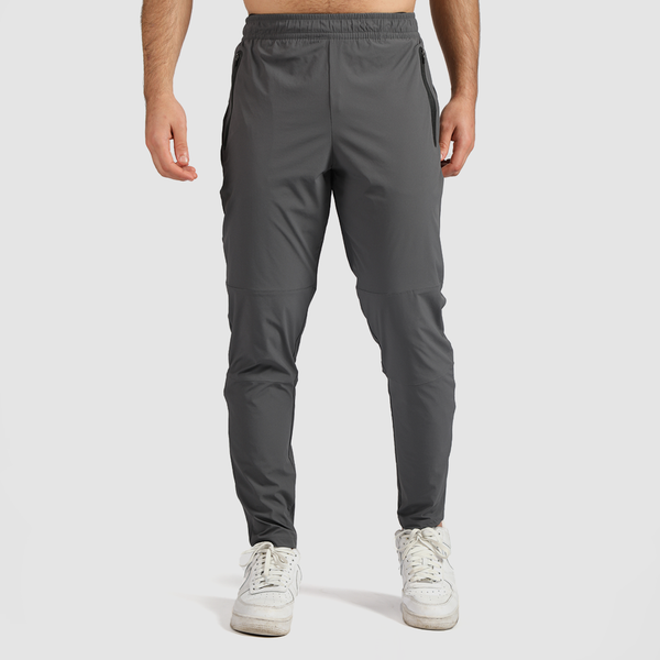 A man wearing quiet shade grey joggers and white sneakers.