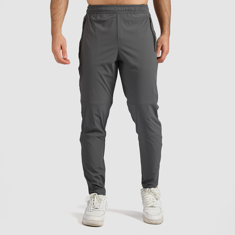 A man wearing quiet shade grey joggers and white sneakers.