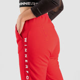 close up view  for fit woman wearing jogger pants with beige logo ,plus the background is light grey 