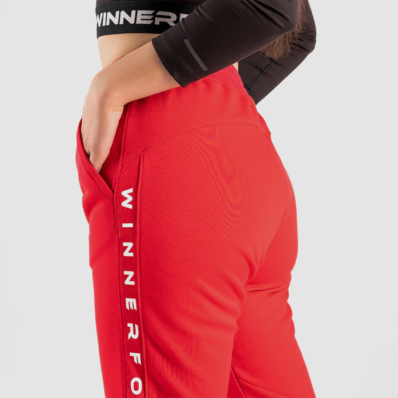 close up view  for fit woman wearing jogger pants with beige logo ,plus the background is light grey 