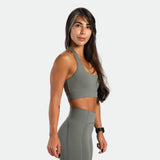 a fit woman stand at right and wearing matching set sage grey ,bra and short 