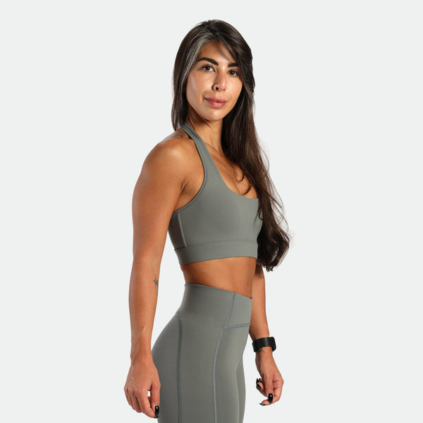 a fit woman stand at right and wearing matching set sage grey ,bra and short 