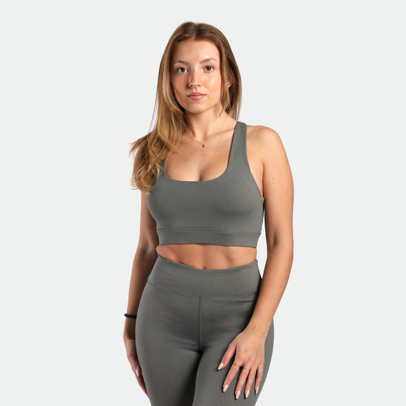 a fit woman wearing  matching set sage grey terrazzo ,bra and legging 