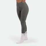 a fit woman stand at right and wearing legging sage grey terrazzo with socks white 