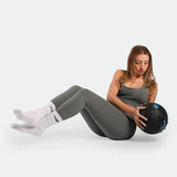 Woman exercising with a medicine ball on a white background ,she wearing matching set sage grey terrazzo blue  plus the sucks white 