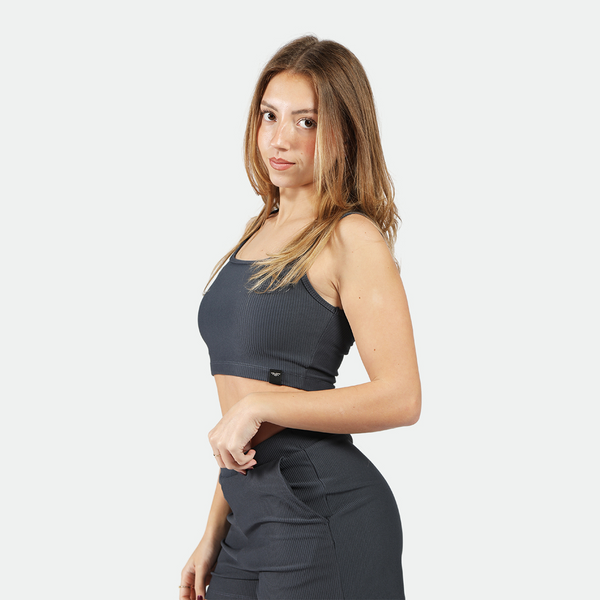 a fit woman wearing matching crop top and short grey 