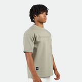 a fit man stand at right  and wearing t-shirt seagrass green with short white 