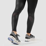a fit woman  stand  at right and wearing  legging black   ,she wearing shoes  mix color , plus the background is light grey  