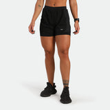 Person wearing black athletic shorts on a white background