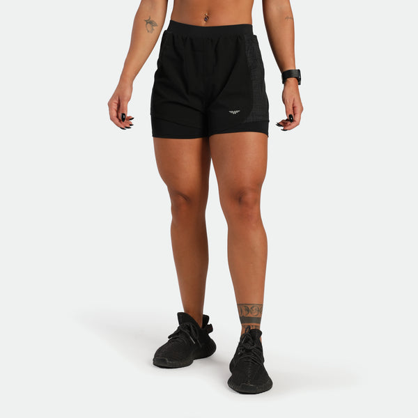 Person wearing black athletic shorts on a white background