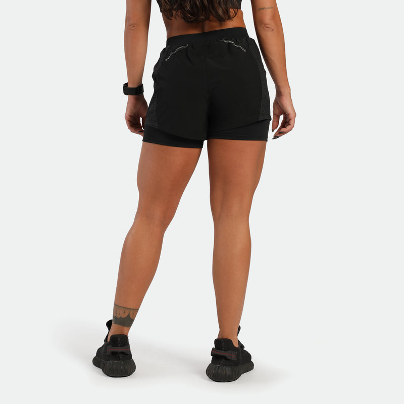 Person wearing black athletic shorts on a white background