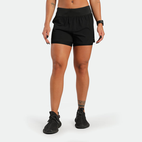 Person wearing black athletic shorts on a white background