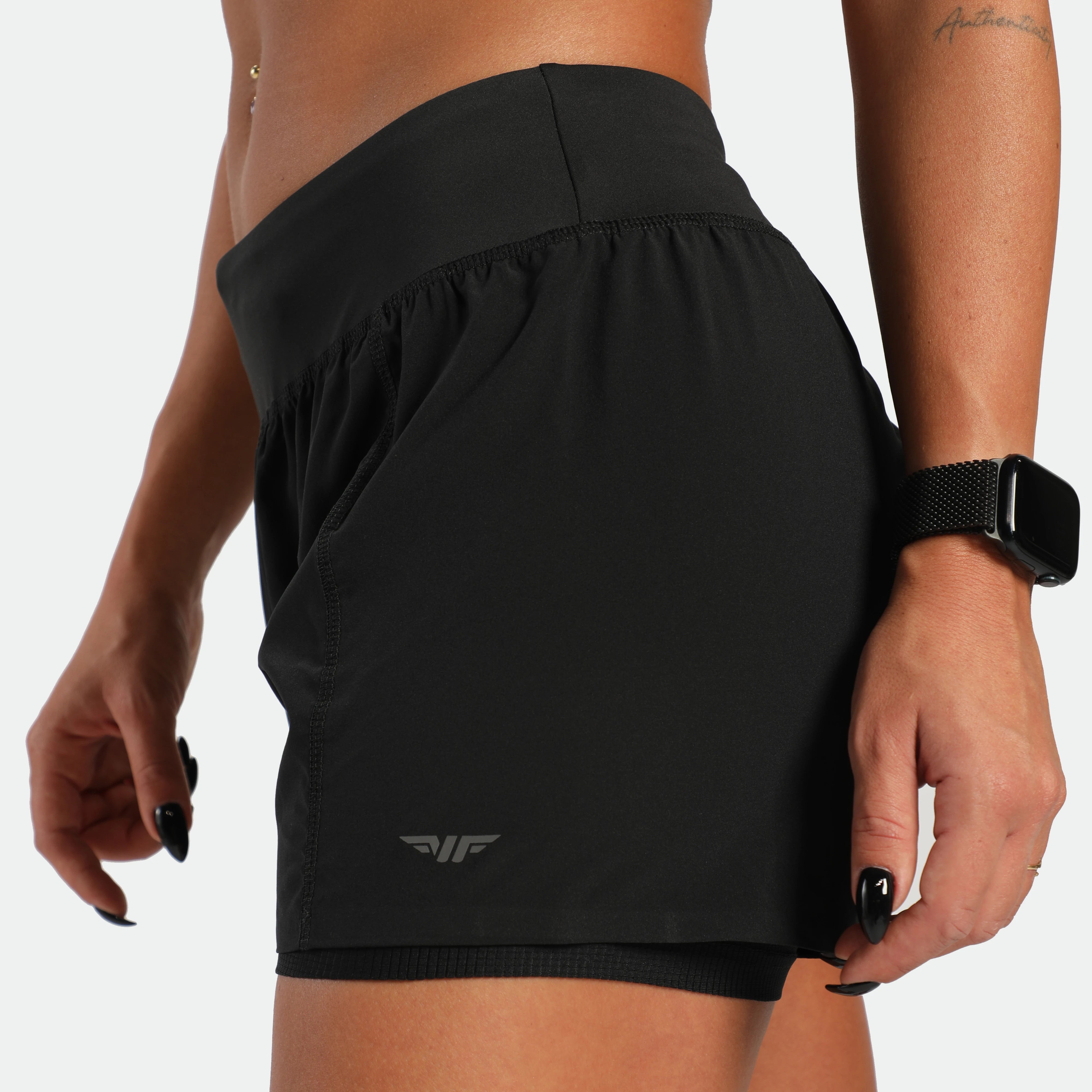 Black athletic skirt worn by a person on a plain background
