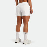 Person wearing white athletic shorts on a white background