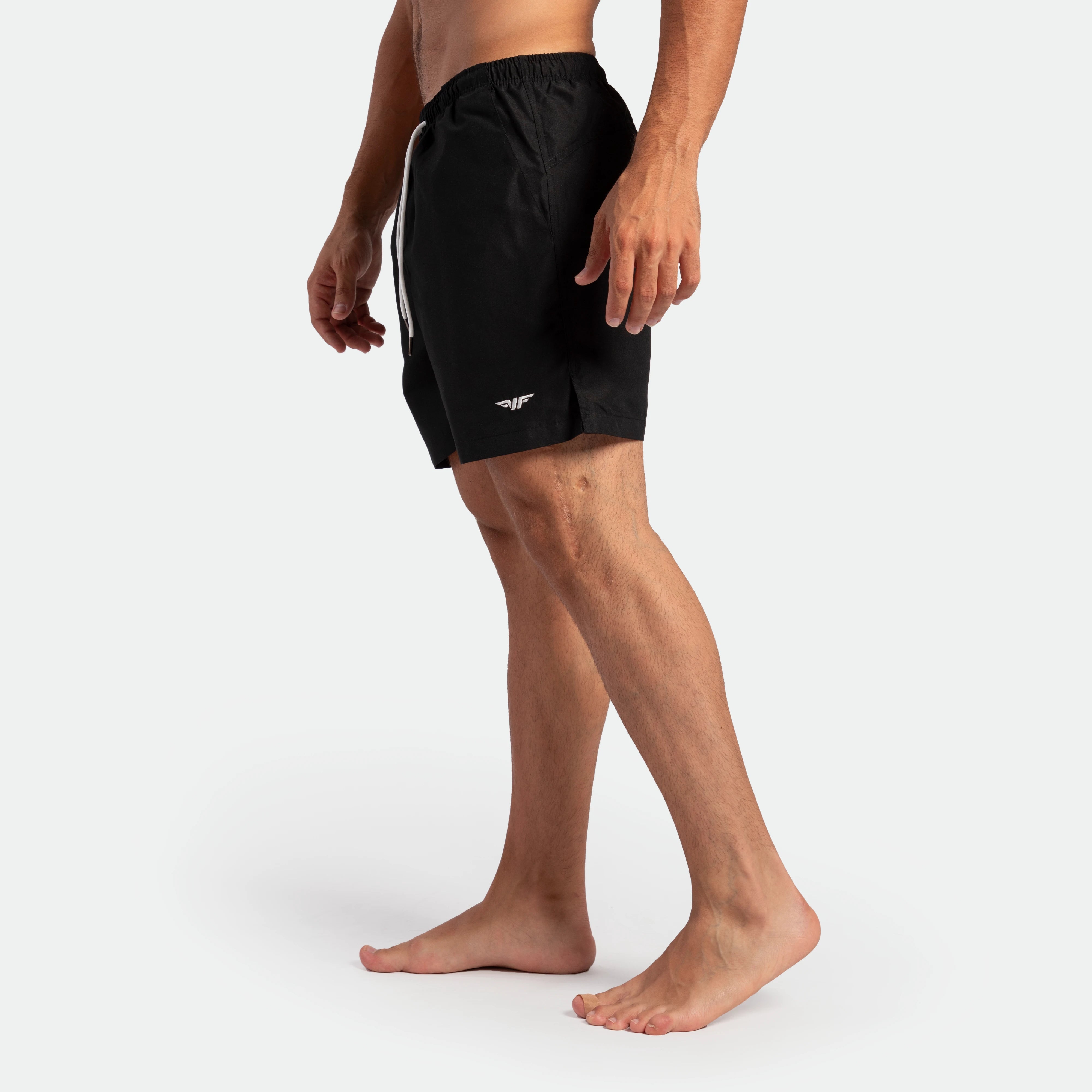 a fit man stand at right and wearing short black 