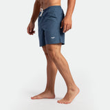 a fit man stand at right and wearing short ensign blue  