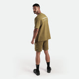a back view for fit man wearing matching set olive drop t-shirt and short  with socks and shoes black 