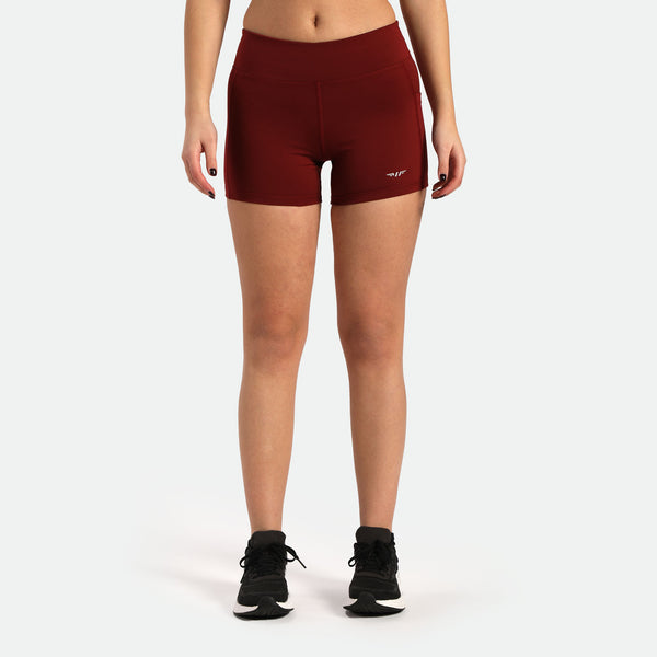 a fit woman wearing short red with logo and shoes black  plus the background is light grey 