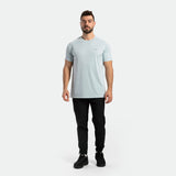a fit man wearing t-shirt sky blue with pants black ,plus the shoes black 