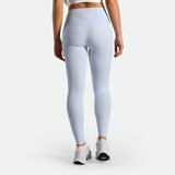 a back view for fit woman wearing legging sky blue with shoes white 