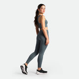 Woman wearing a gray athletic outfit on a white background
