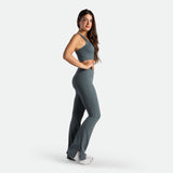 a fit woman stand at right and wearing matching set stormy grey ,crop top with flared legging ,plus the shoes white 