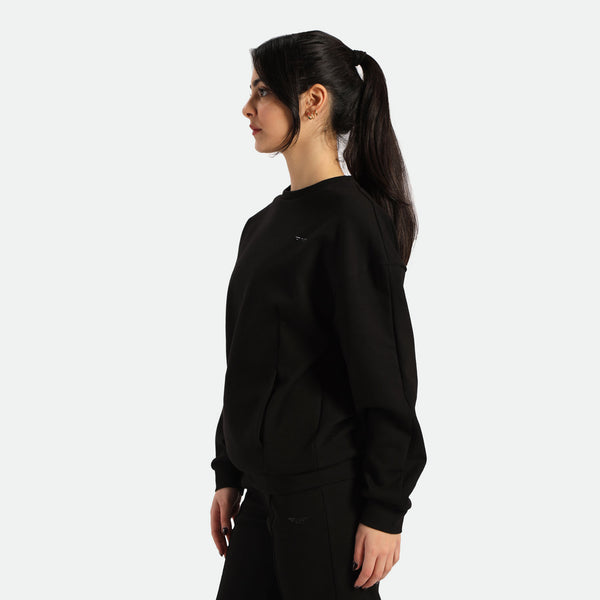 a fit woman  stand at right wearing sweatshirt and pants black 