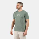 a fit man wearing t-shirt agave green with logo ,and pants beige 