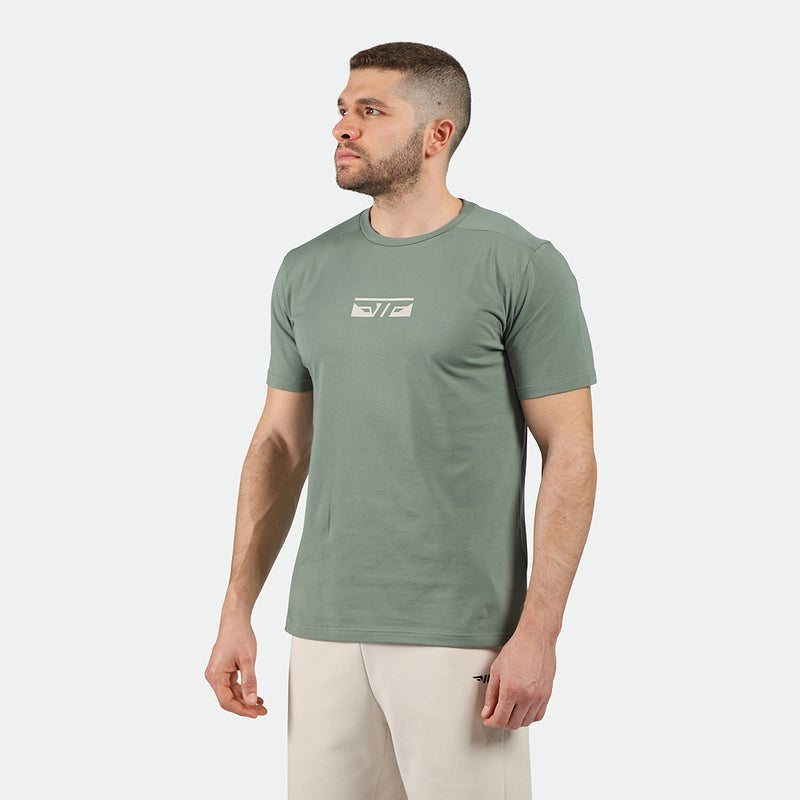 a fit man wearing t-shirt agave green with logo ,and pants beige 