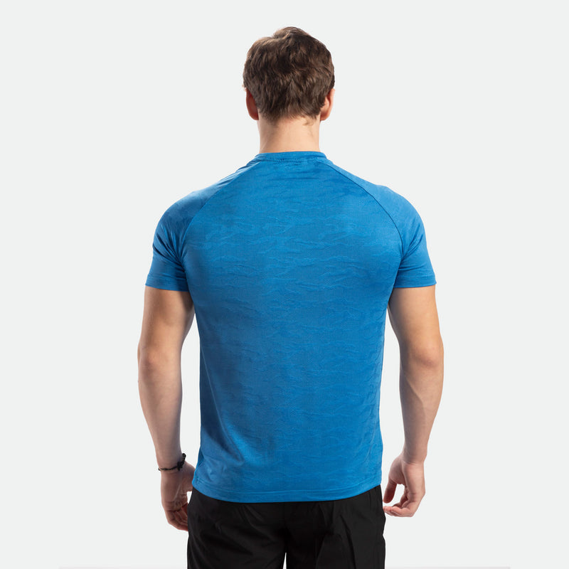 a back view for fit man  wearing t-shirt camo azure blue  with pants black 