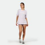 a fit woman stand with pose and wearing t-shirt lavender with short purple and sneakers