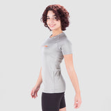 a fit woman stand at right and wearing t-shirt grey with short black 
