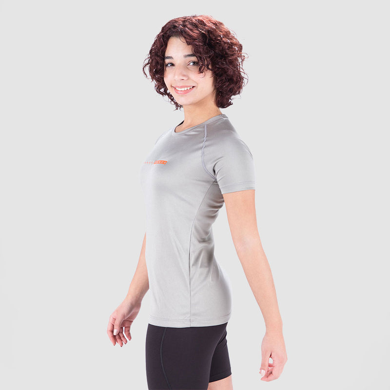 a fit woman stand at right and wearing t-shirt grey with short black 