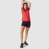 a fit woman wearing t-shirt red with short black and sneakers 