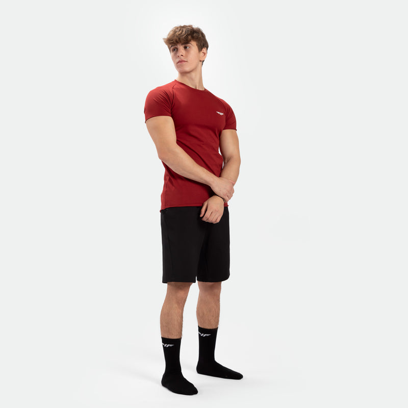 a fit man wearing t-shirt dark red with short black and socks black 