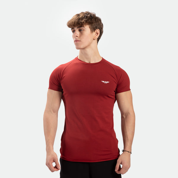 a fit man wearing t-shirt  tomato dark red  with logo ,plus pants black 