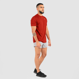 a fit man stand at right and wearing t-shirt tomato red with short grey ,plus the shoes black 