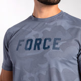 Close-up of a person wearing a gray camo-patterned athletic shirt with the word "FORCE" in bold letters. The mood is active and empowering.