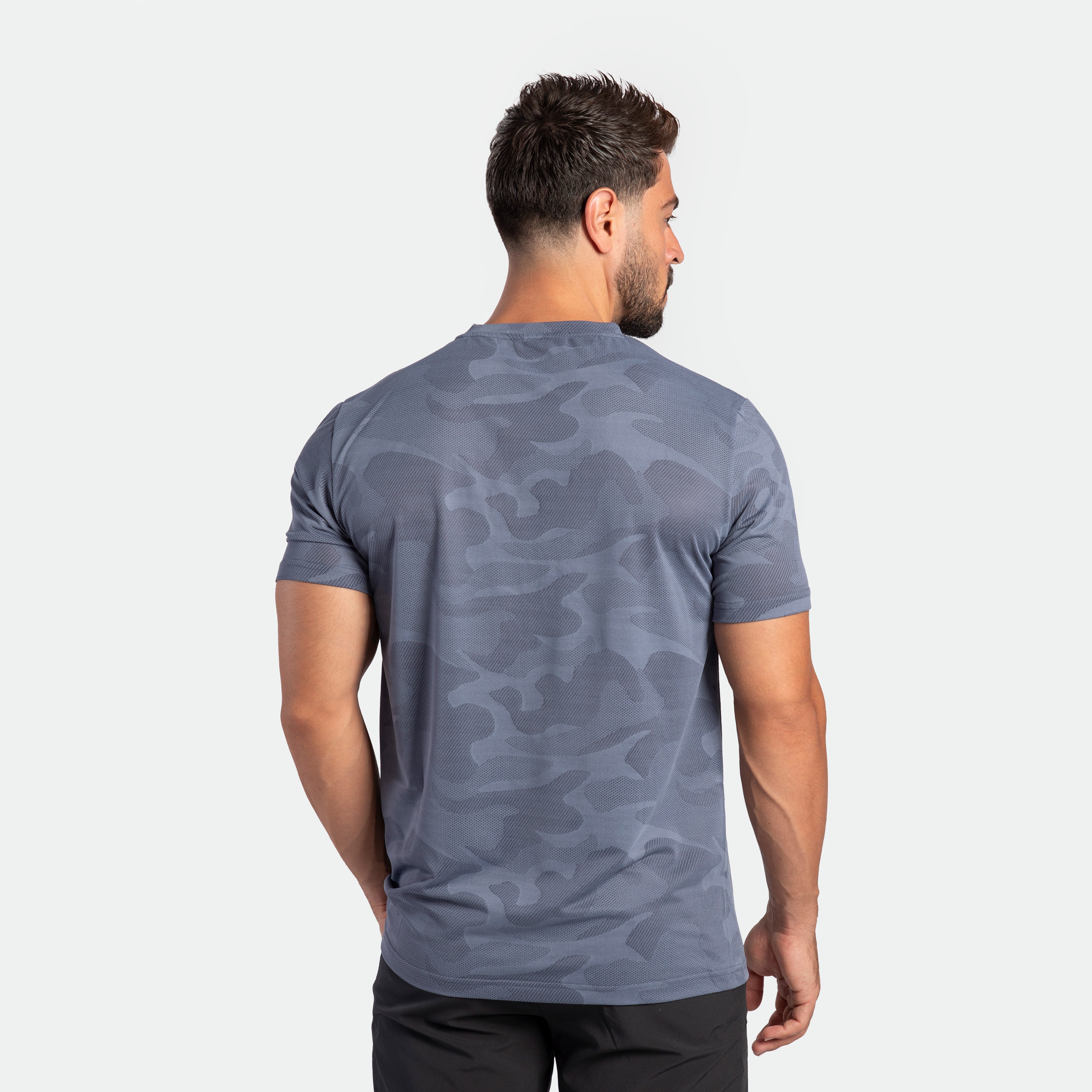 a back view for fit man wearing  camo t-shirt VINTAGE-INDIGO with pants black 